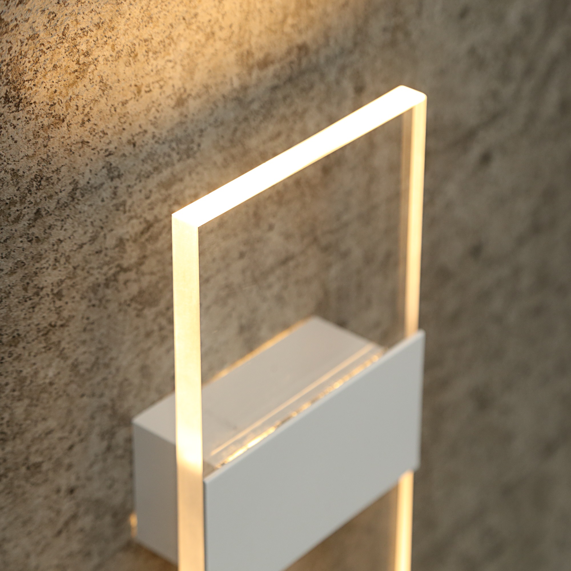 Arandela moderna de alumínio Giulia instalada em parede, com design retangular minimalista e iluminação suave, ideal para corredor, lavabo ou cabeceira de cama.